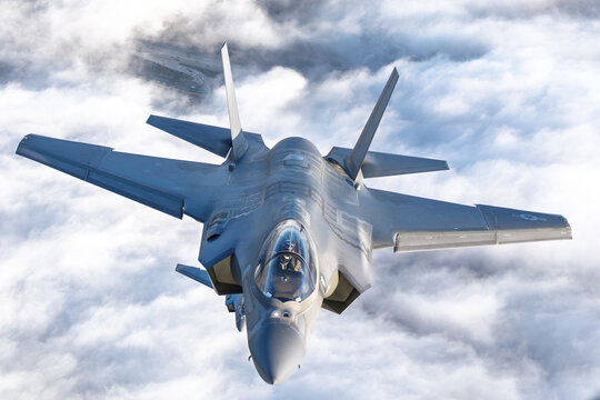 Very  close top view of a pair of F-35C Lightning II   over clouds in beautiful light