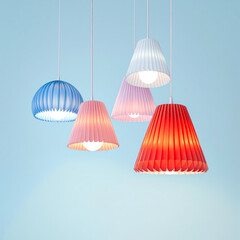five pastel-colored pleated pendant lights hanging against a light blue wall