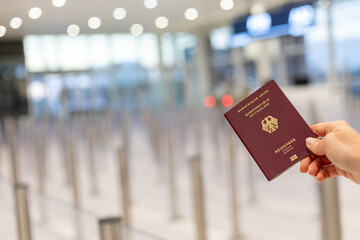 Passport held at airport security during travel check-in process in a busy terminal