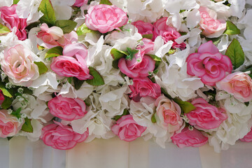 closeup pink and white roses flower arrange overlays and leaves on a white cloth wall background, nature, love, valentine, wedding, copy space