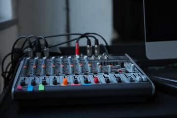 Modern audio mixing console on black table indoors, closeup. Music equipment