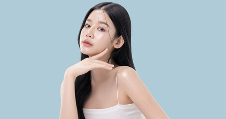 Glowing skin make up style of beautiful young Asian model isolated on blue background.