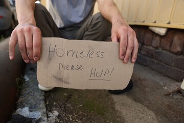 Man with sign Homeless please help outdoors, closeup