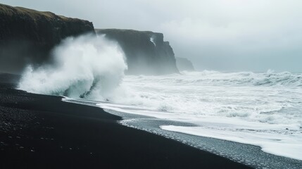 Fototapeta premium Dramatic seascape with crashing waves on a black sand beach near cliffs