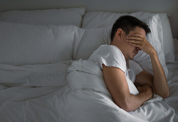 Sleepless man lying in bed feeling tired stressed	