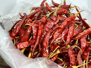 dried red chili peppers, bright red color, slender shape, and thin skin.