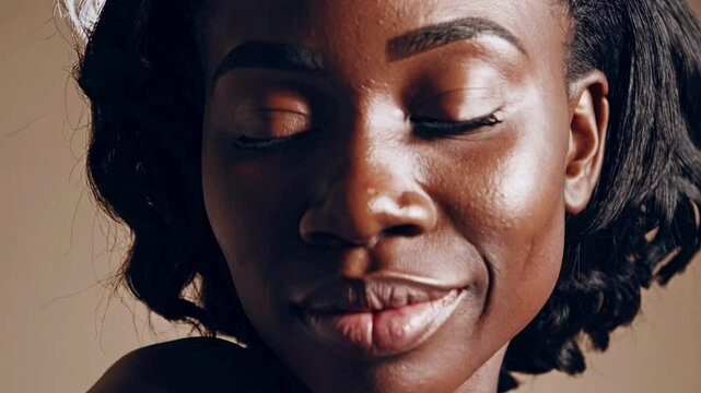 Close-up portrait of a woman with natural lighting, showcasing smooth skin texture. The camera angle is straight-on, suitable for a video profile shot.