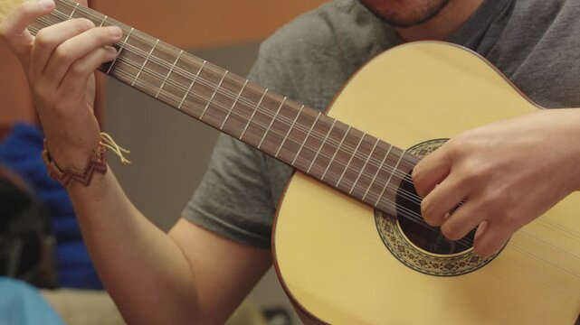 Close-up of hands playing colombian Tiple, a traditional Andean string instrument.