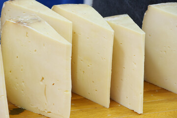 Delicious cheese slices arranged on a wooden cutting board