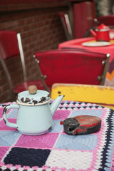 Rustic kettle on an antique table in a vibrant cafe setting