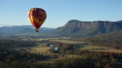 Obraz premium Colorful hot air balloon over a valley landscape.