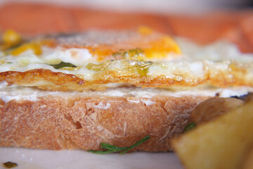 Delicious egg on toast with crispy edges served with potatoes