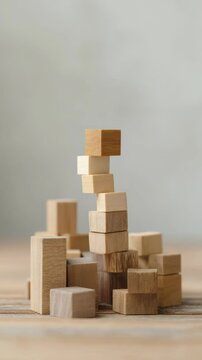 Precarious stack of wooden toy blocks demonstrating risk, unstable foundations and delicate balance on wooden surface.