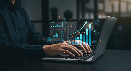 Analyzing financial data on a laptop with holographic charts showing business growth, showcasing a data-driven approach to success.