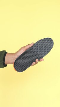 Unique shoe insole displayed against vibrant yellow background