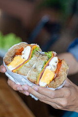 Person holding half cut sandwich