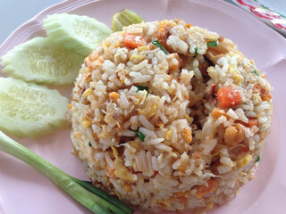 fried rice, Thai styleFried Rice with cucumber, lime and green sprig onion on pink plate
