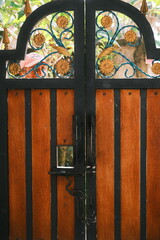 Elegant Wooden Metal Gate With Ornamental Floral Design in Outdoor Setting