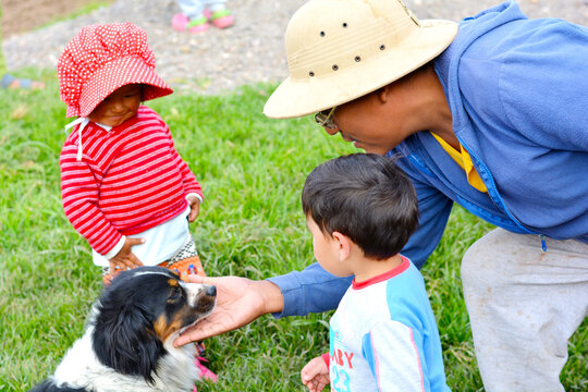 Aymara family patting a dog.