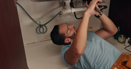 Plumbing, maintenance and man with wrench by sink for repairs, manual labor or trade for home improvement. Handyman, expert and person fixing pipes for leakage, drainage and service with tools
