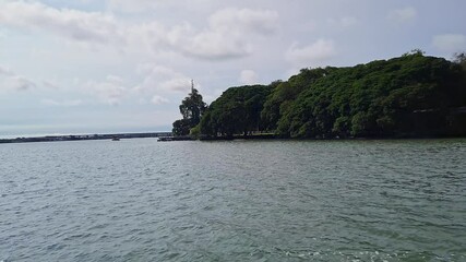 Scenic view of the island or riverbank with cloudy skies, seen from a metro boat bus
