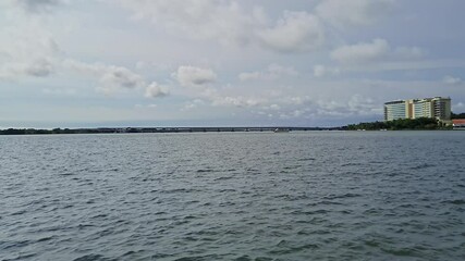 Scenic view of the riverbank with cloudy skies, seen from a speeding metro boat bus