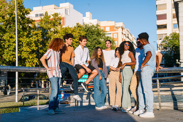 Diverse group of stylish young people enjoying time together outdoors, chatting and relaxing in a modern city setting