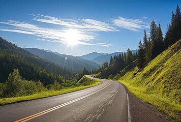 Fototapeta premium Scenic Mountain Road With Asphalt Pavement Through Green Forest Valley Under Bright Sunlight and Blue Sky With White Clouds in Summer