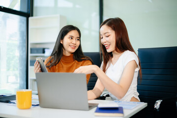 Two business women of young and middle age talking working in Teamwork Finance, Marketing at the office.