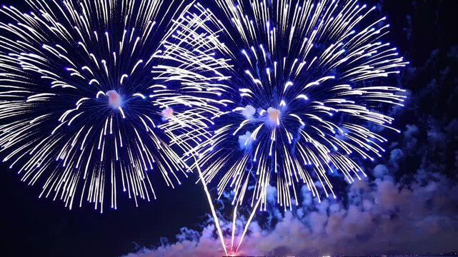 Spectacular night fireworks burst illuminate sky with vibrant colors and dazzling patterns