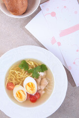Chicken noodle soup. Chicken broth with egg. Dietary dish. Flat lay. Top view.