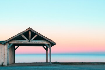 Fototapeta premium Rustic beach shelter under a pastel sky.