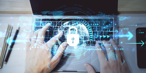 Person typing on laptop with cybersecurity padlock icon overlay, digital arrows and data concept on light background in business setting.