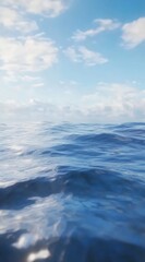 Azure ocean surface, soft waves,  bright sky with scattered clouds.  Delicate, hazy atmosphere