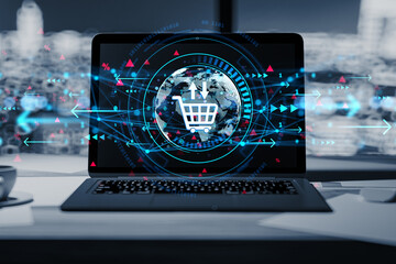 Futuristic ecommerce concept with digital shopping cart icon on laptop screen at office desk with city background and data graphics overlay.