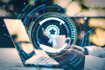 Digital badge symbol over mobile phone and laptop representing online certification and quality assurance in business technology environment.