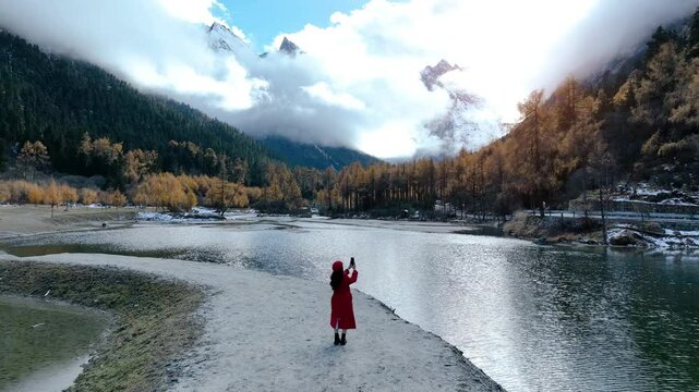 Tourist taking a photo at Bipenggou national park in autumn, Chengdu in China.