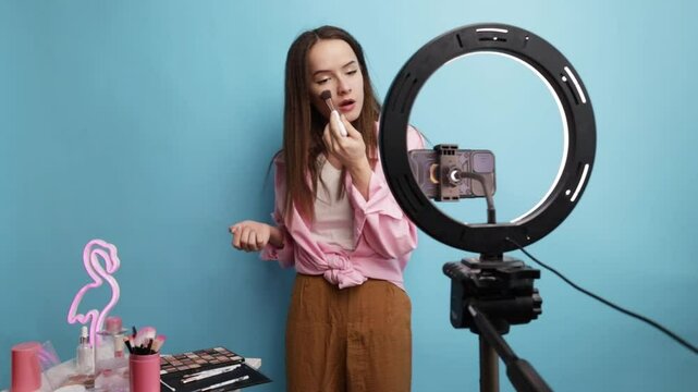 Makeup Content Creator Filming Skincare or Cosmetic Video with Flamingo Light Decoration