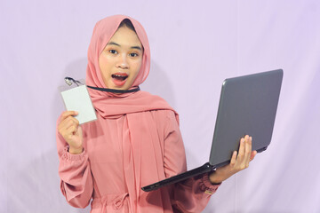 Portrait of a smart-faced Muslim female student wearing glasses, holding her laptop