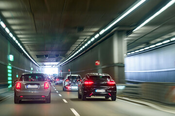 Obraz premium Driving through a modern tunnel with cars in motion during daylight