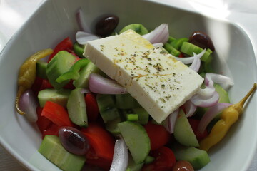 Greek salad with cucumbers, tomatoes, olives, peppers, cheese