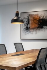 Modern conference room with minimalist design.  A light-colored wooden conference table, dark gray ergonomic chairs, a black pendant lamp, and a large abstract painting