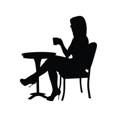 Silhouette of a woman sitting at a table enjoying a cup of coffee