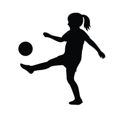 Silhouette of a young girl playing soccer, kicking the ball