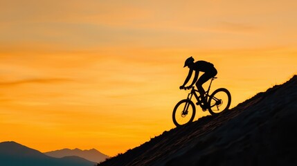 Obraz premium Silhouette of Mountain Biker Riding Up Hill Against Vibrant Sunset