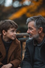 Fototapeta premium Grandfather and grandson sharing a heartfelt conversation in an autumn park