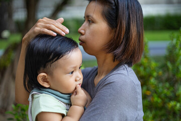 Mother Carries Her Child While Enjoying In The Garden