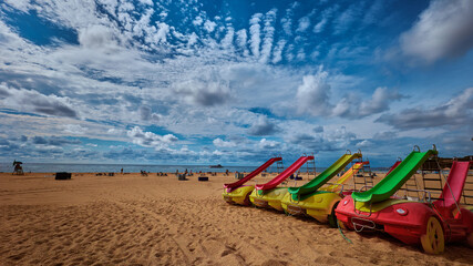 Water bickes on central city beach with beautiful clouds in the sky. Lloret de Mar, Girona region, Spain. Costa Brava. Mediterranean Sea