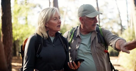 Phone, hiking and couple in forest for direction, destination discussion or lost in woods. Mobile, senior man and woman trekking, reading map or pointing for navigation app with location for travel - Powered by Adobe