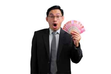 Excited young Asian businessman holding money bills with mouth open isolated on transparent background